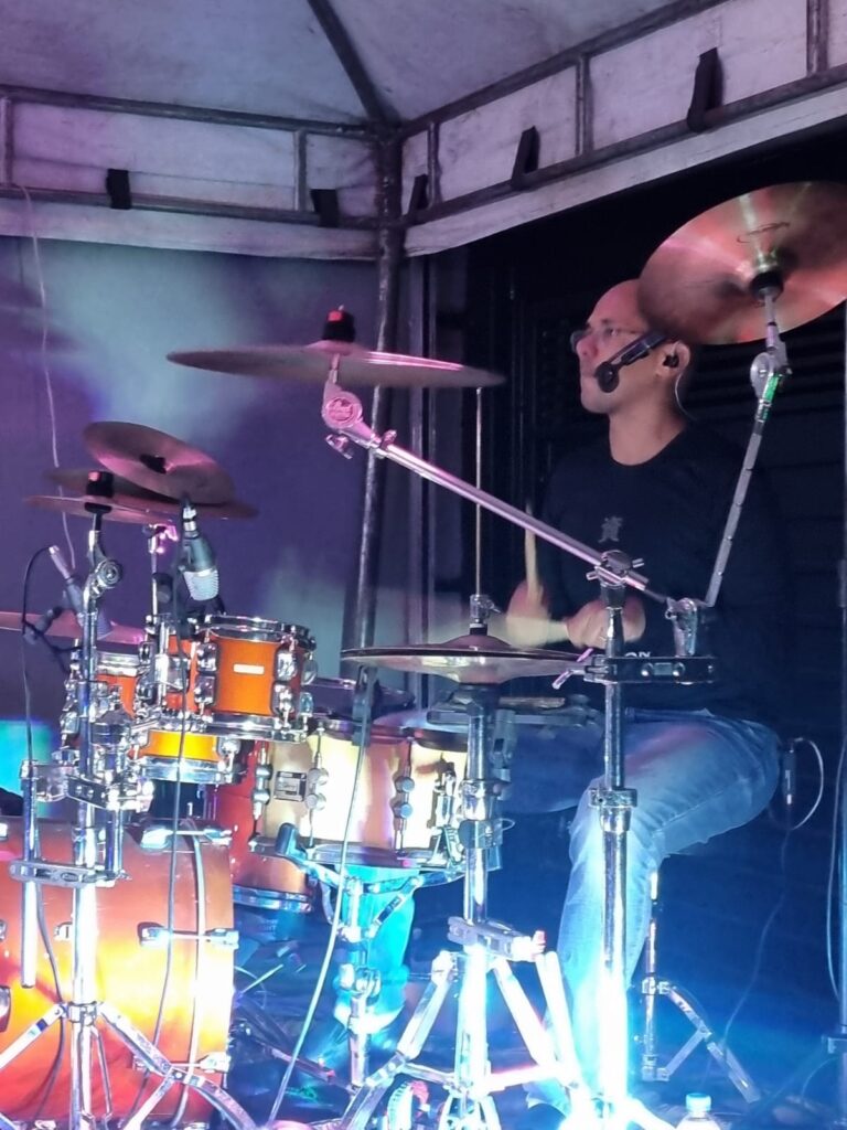 Baterista da Kalhambex em palco iluminado