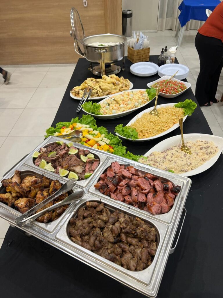 Buffet de churrasco com carnes, linguiça, frango e coração no rechaud, saladas e guarnições, no Rio de Janeiro