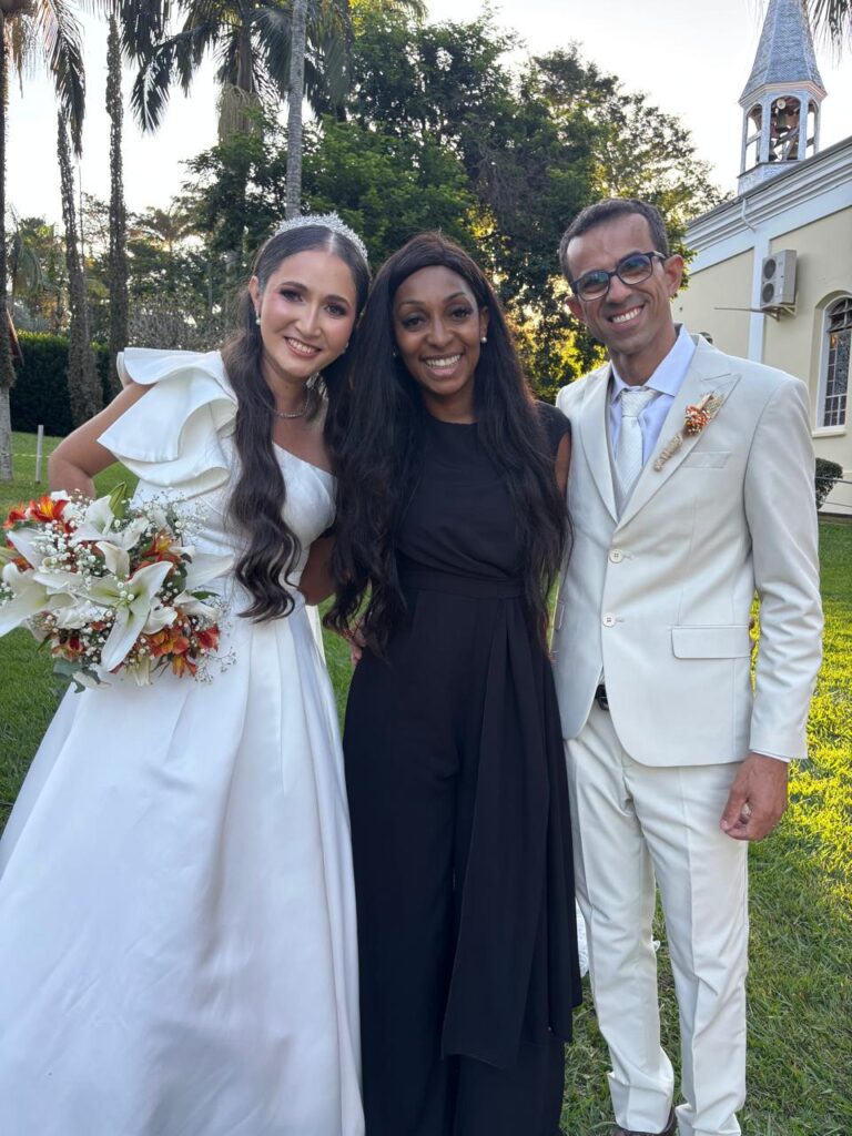 Noivos e cerimonialista em casamento próximo a uma capela
