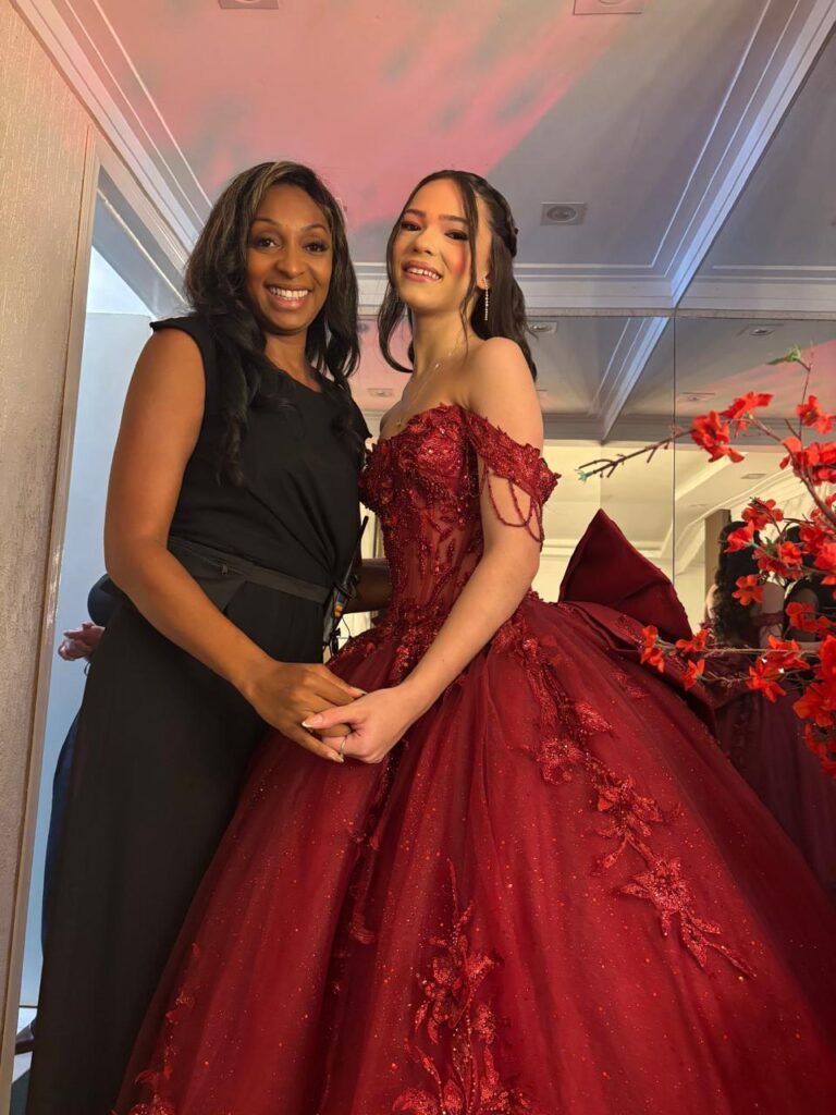 Debutante de vestido vermelho bordado ao lado da cerimonialista