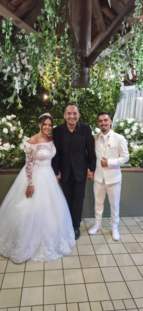 Cerimonialista com os noivos em casamento ao ar livre