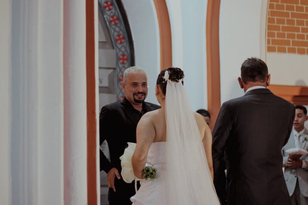 Cerimonialista recebendo a noiva na entrada da igreja em casamento