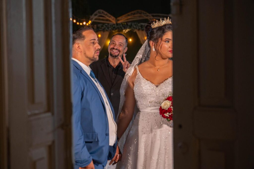 Cerimonialista sorrindo com os noivos na entrada da cerimônia de casamento