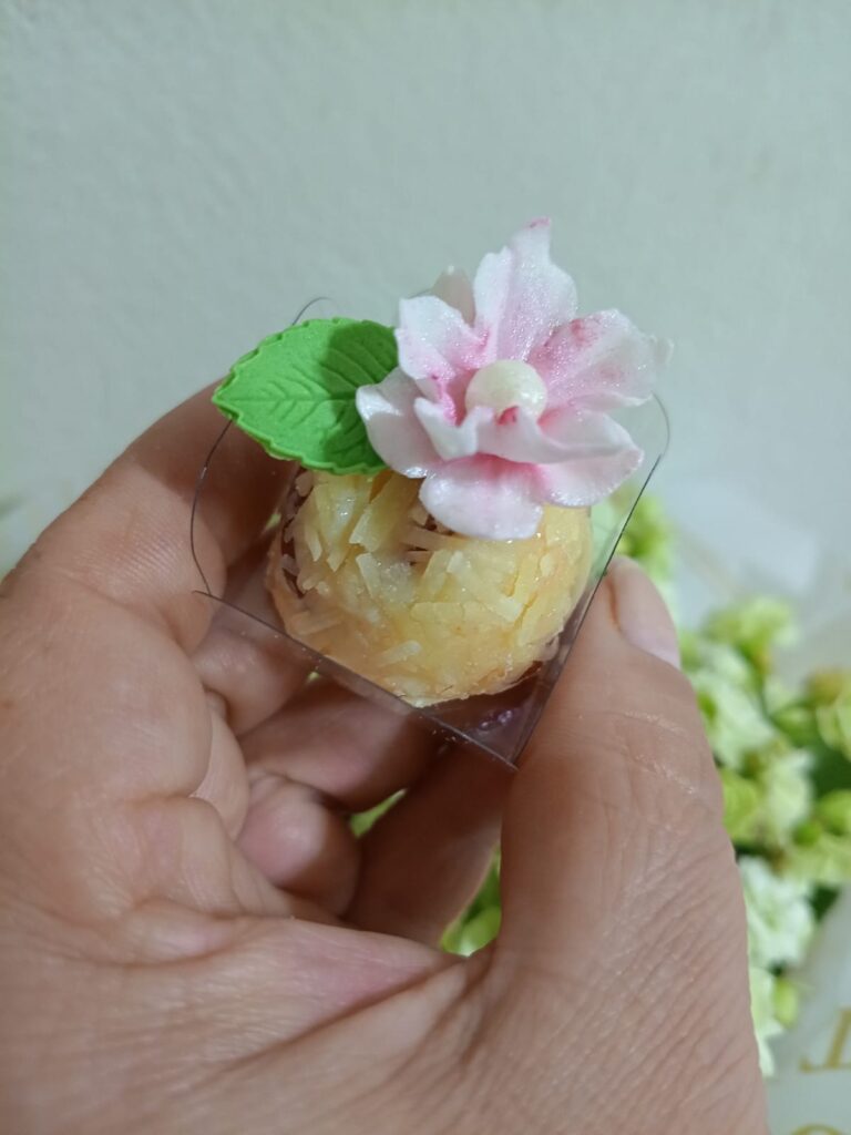 Doce de coco com flor comestível rosa e folha da Chocofruttini