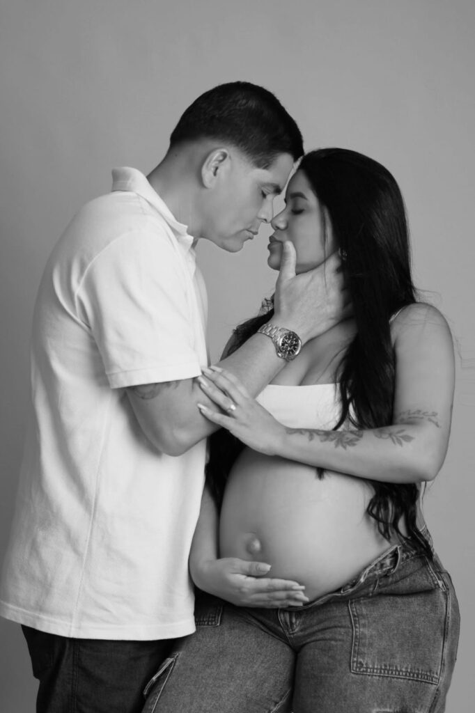 Ensaio de gestante em preto e branco, casal com testa encostada e mãos na barriga