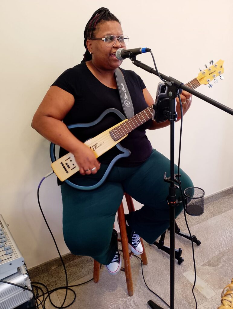 Luana Chimitte cantando e tocando violão em evento