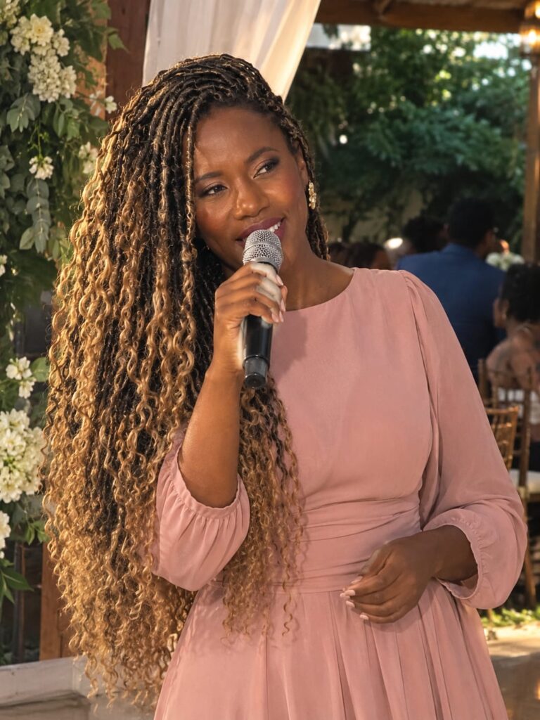 Vivi Amaral cantando em cerimônia de casamento com decoração de flores brancas
