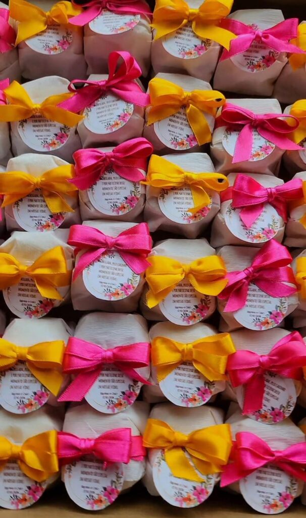 Bem-casados artesanais com fitas rosa e amarela e tags de agradecimento
