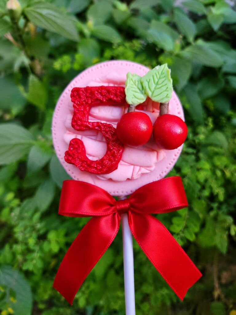 Pirulito de chocolate decorado com número 5 e cerejas