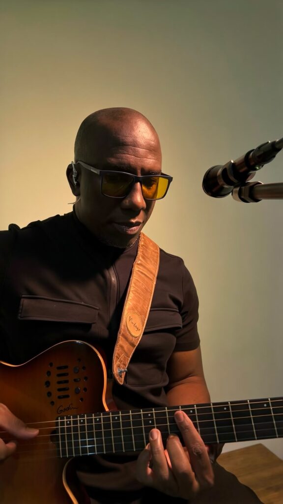 Wilson Carvallho tocando violão e guitarra com microfone